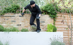 Seguro contra roubo Ladrão a saltar muro de casa