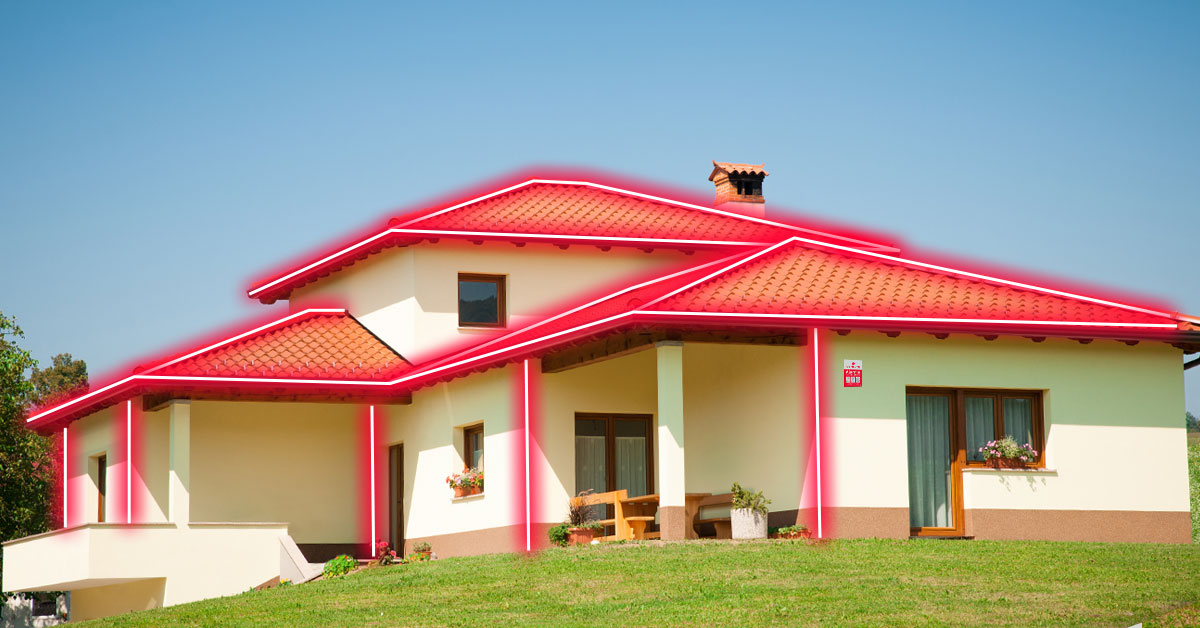 Casa branca com um jardim com linhas vermelhas que indicam a proteção graças à instalação de detetores de intrusão da Securitas Direct com tecnologia Shock Sensor.